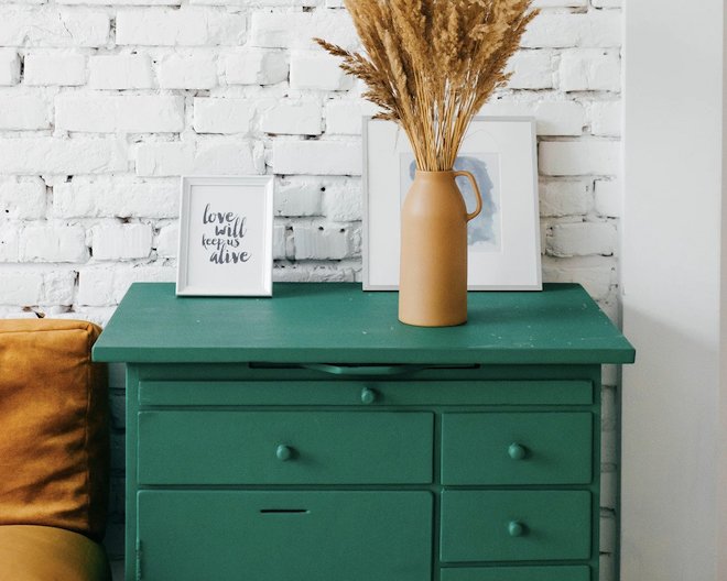 A flower vase on a green drawer